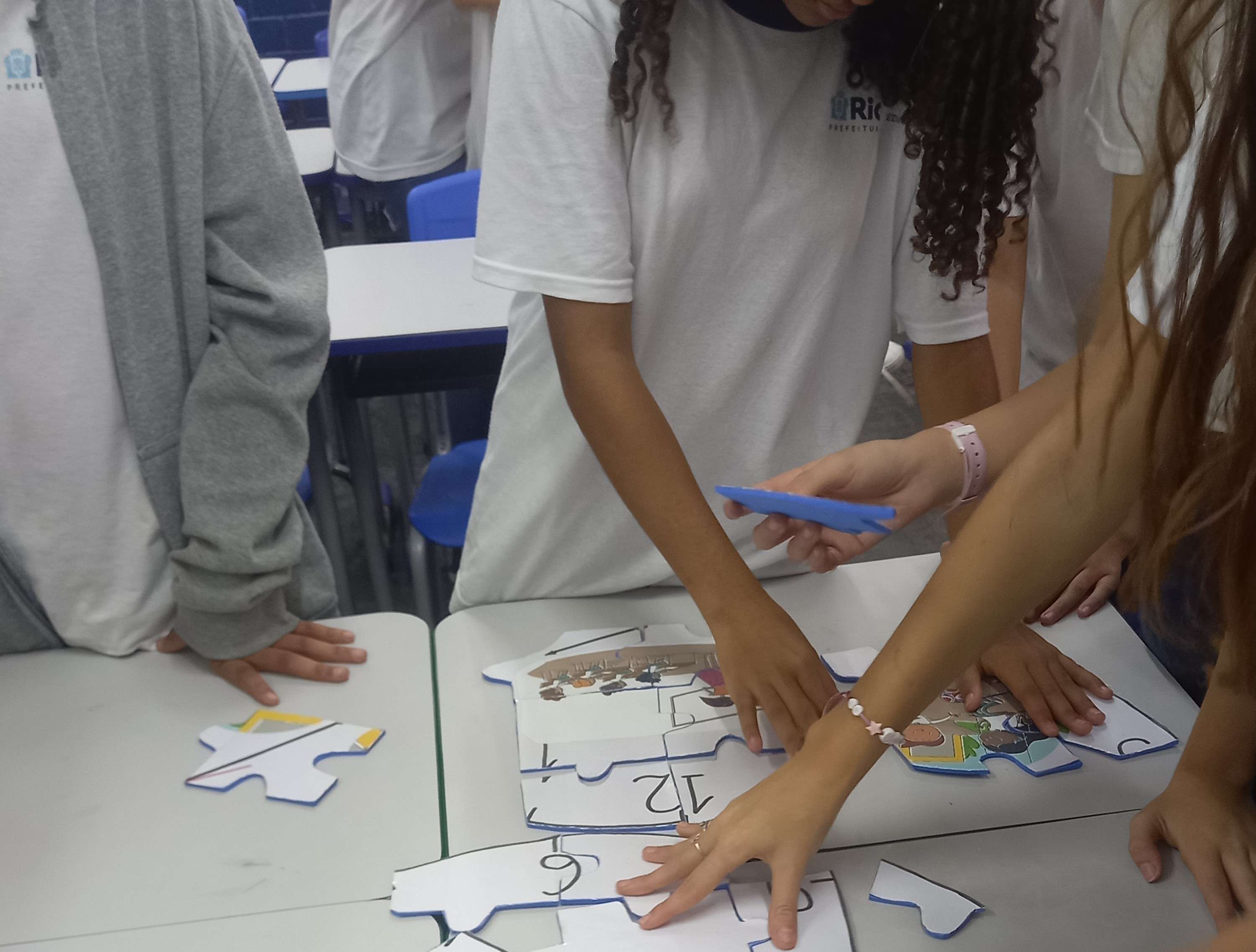 Estudantes montando quebra-cabeça em sala de aula